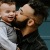 father holds and kisses his toddler son